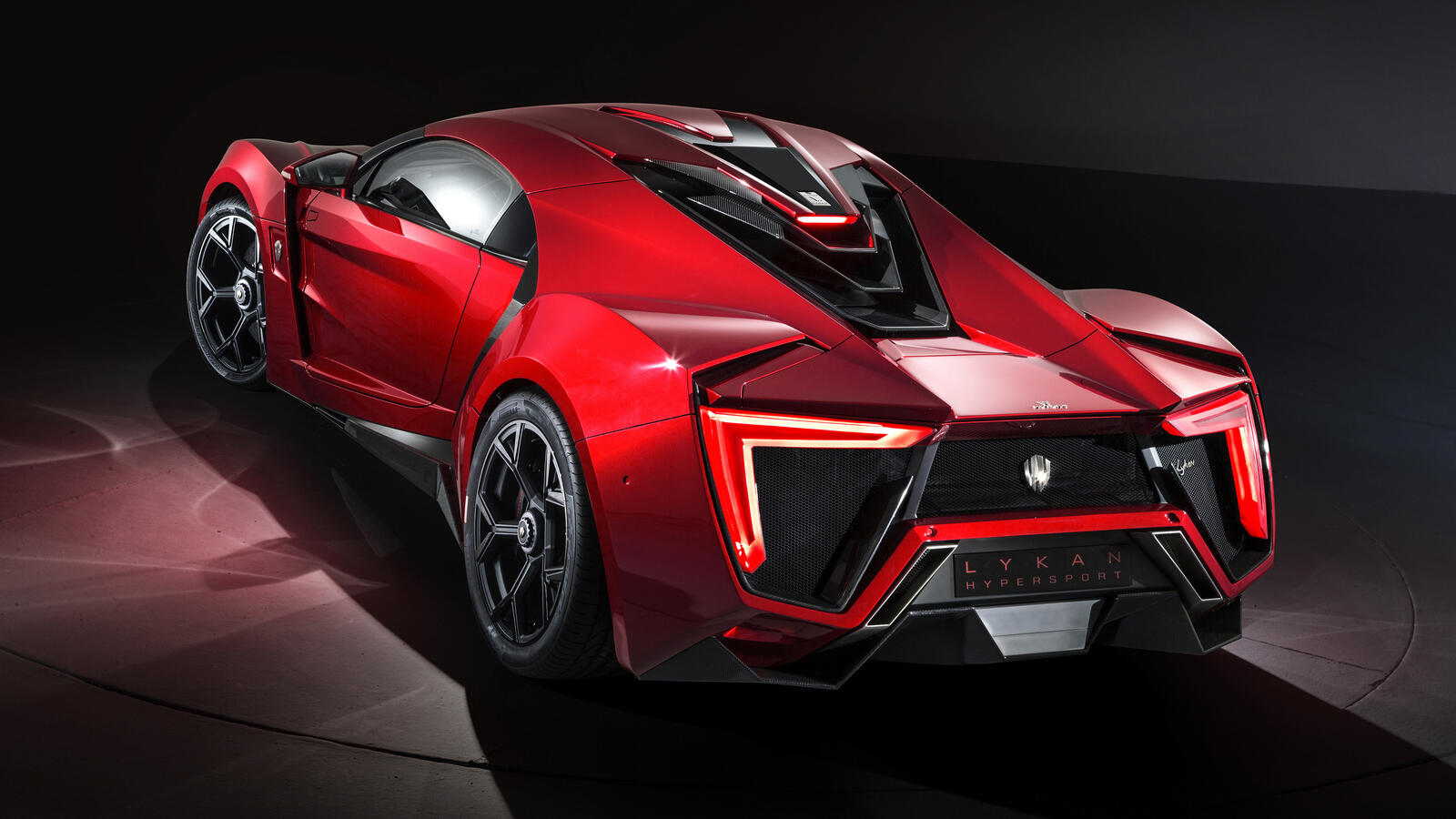Free photo Red Lykan HyperSport supercar on dark background rear view