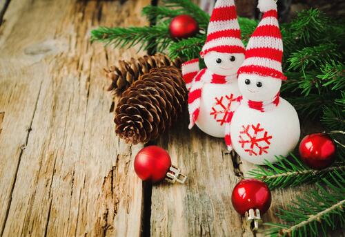 Два игрушечных новогодних снеговика под елкой