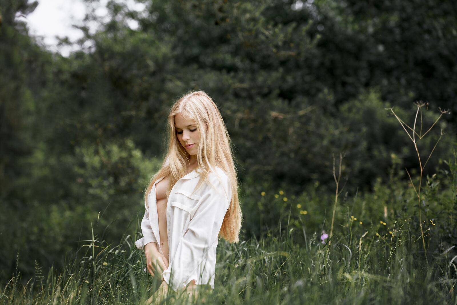 Бесплатное фото Девушка без нижнего белья в белой рубашке на природе