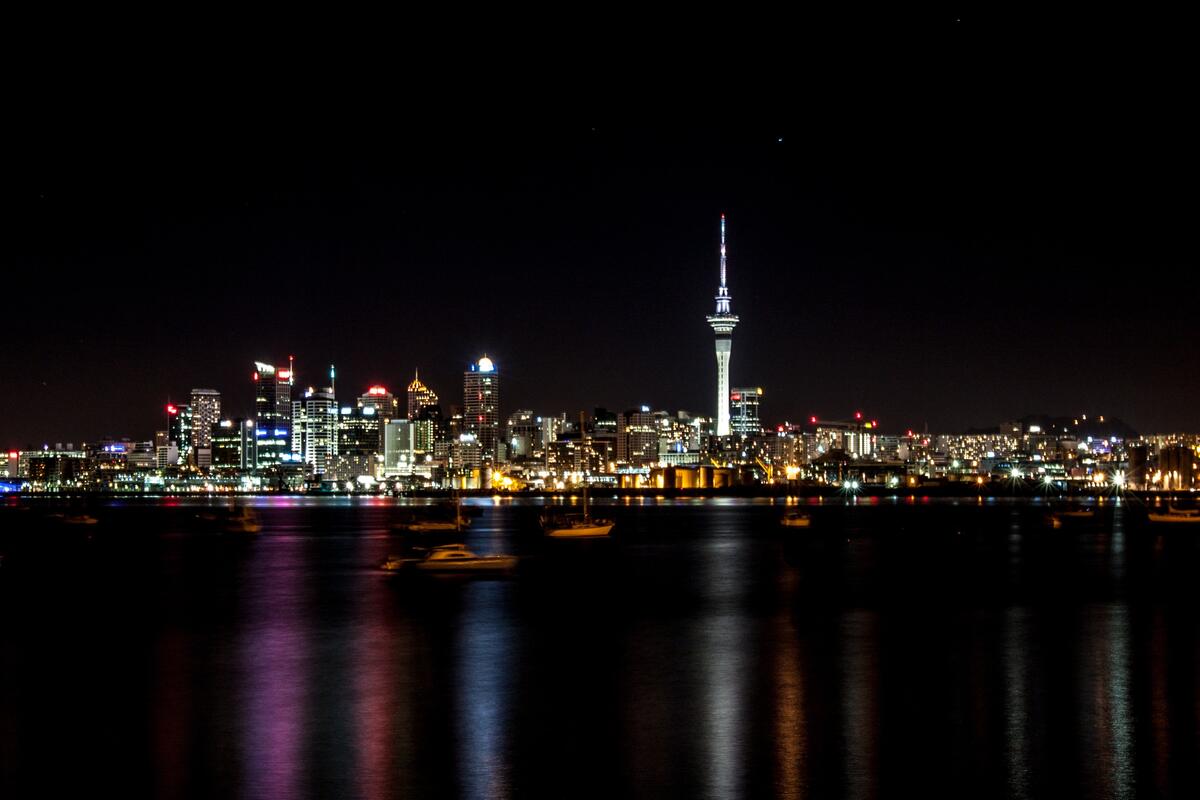 A nighttime city in New Zealand is reflected in the water