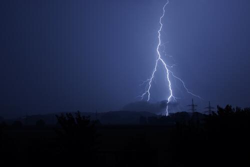 A nighttime flash of lightning in the dark blue sky