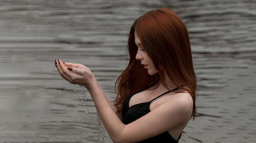 Темноволосая Анна Телышева стоит в реке