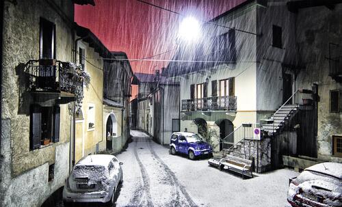 The first snow in the streets of Italy at night