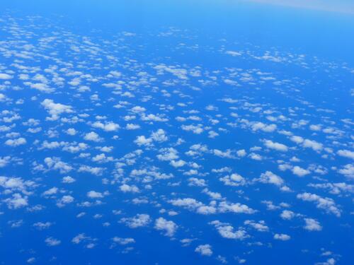 A view of the ocean through the clouds from an airplane