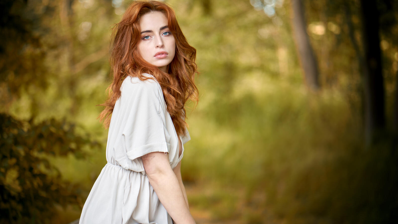Free photo Redheaded girl in a dress in the woods
