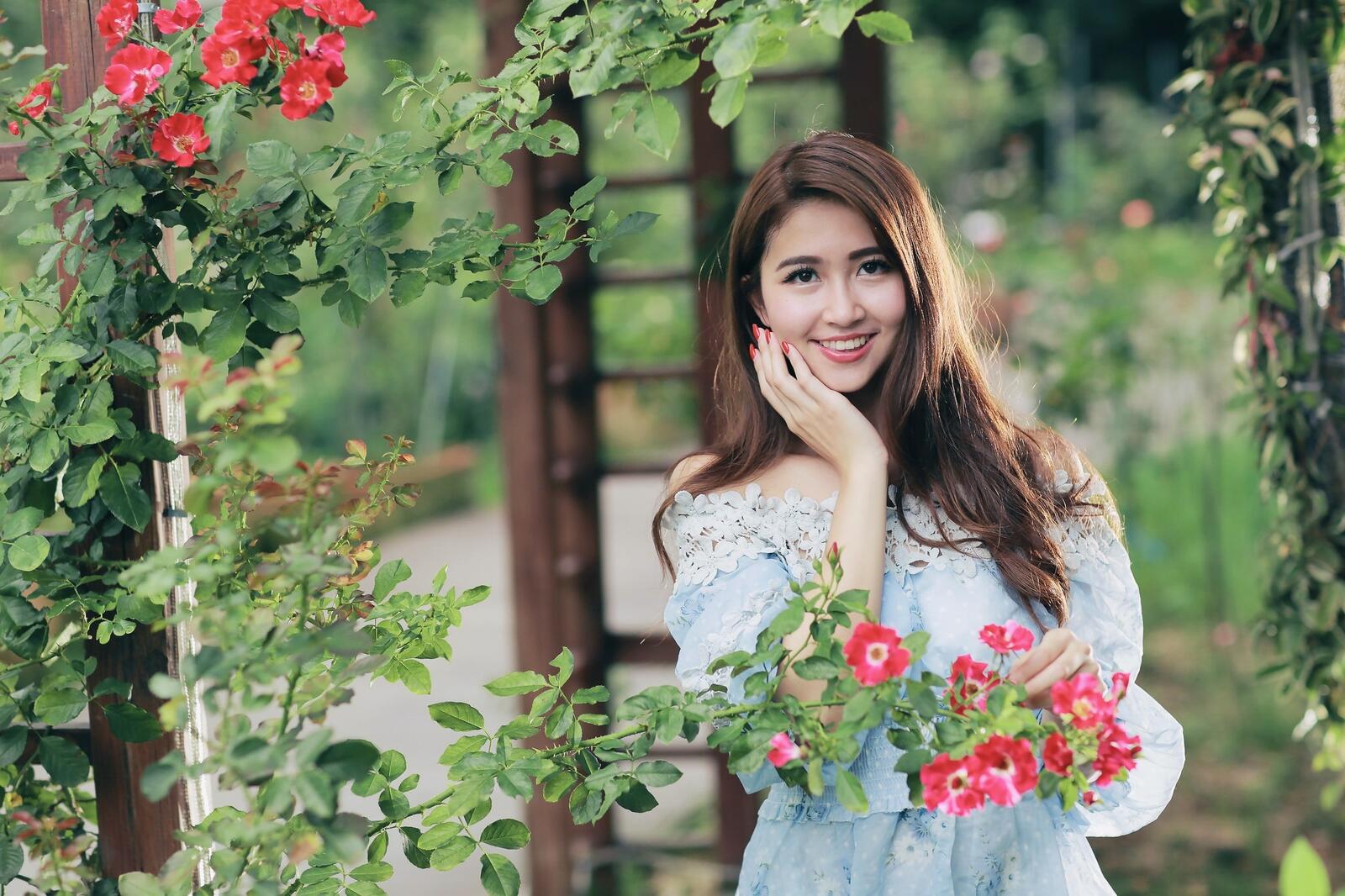Бесплатное фото Азиатка в парке с цветами