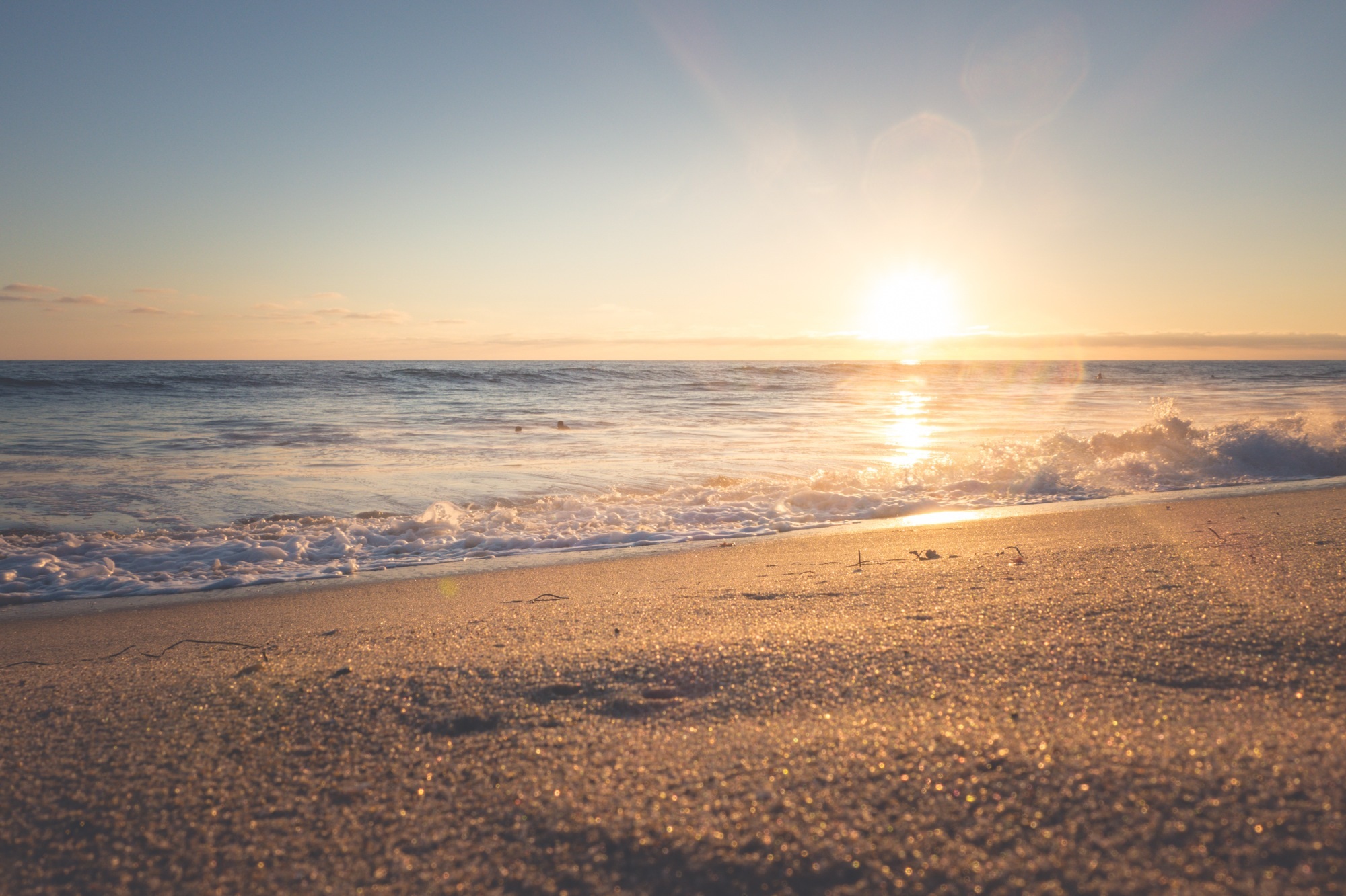 Восход солнце на песочном пляже океана