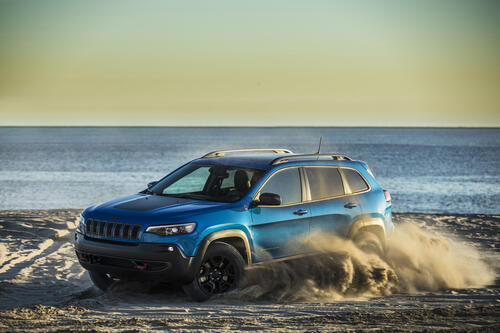 Jeep cherokee trailhawk drives on the sand on the beach