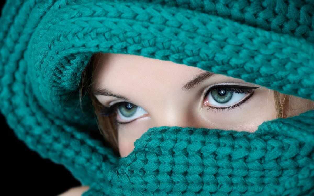A girl with beautiful eyes wrapped in a green scarf