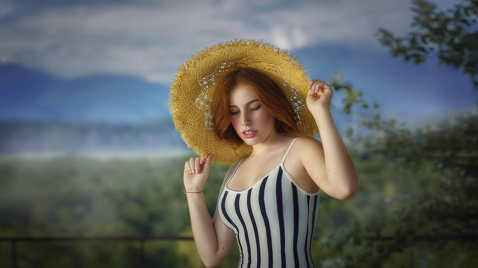 Free photo A redhead in a hat and a striped swimsuit