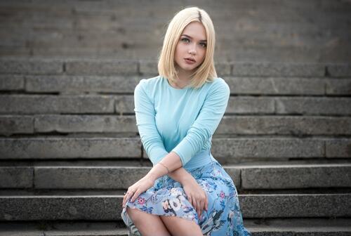 Blond girl sitting on the steps