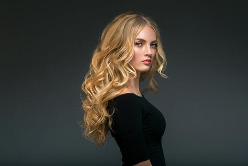 Girl with blond curly hair in a black turtleneck