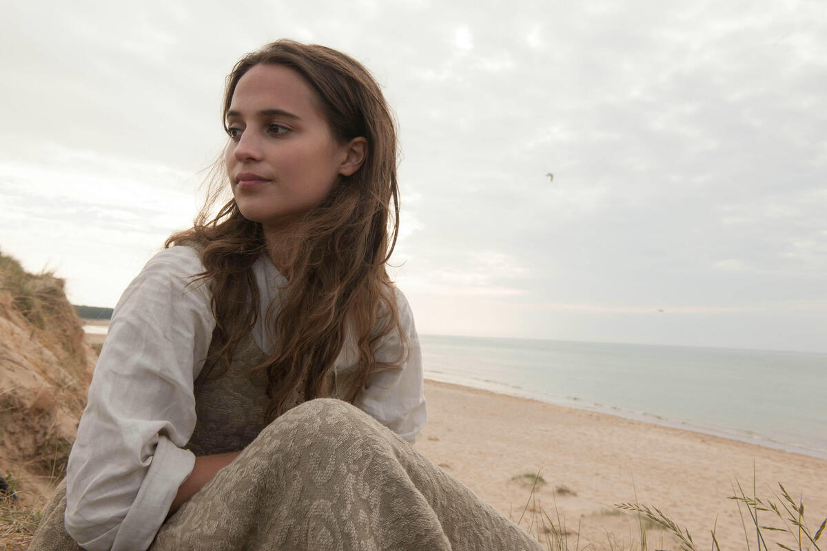 Alicia Vikander on the beach on a cloudy day
