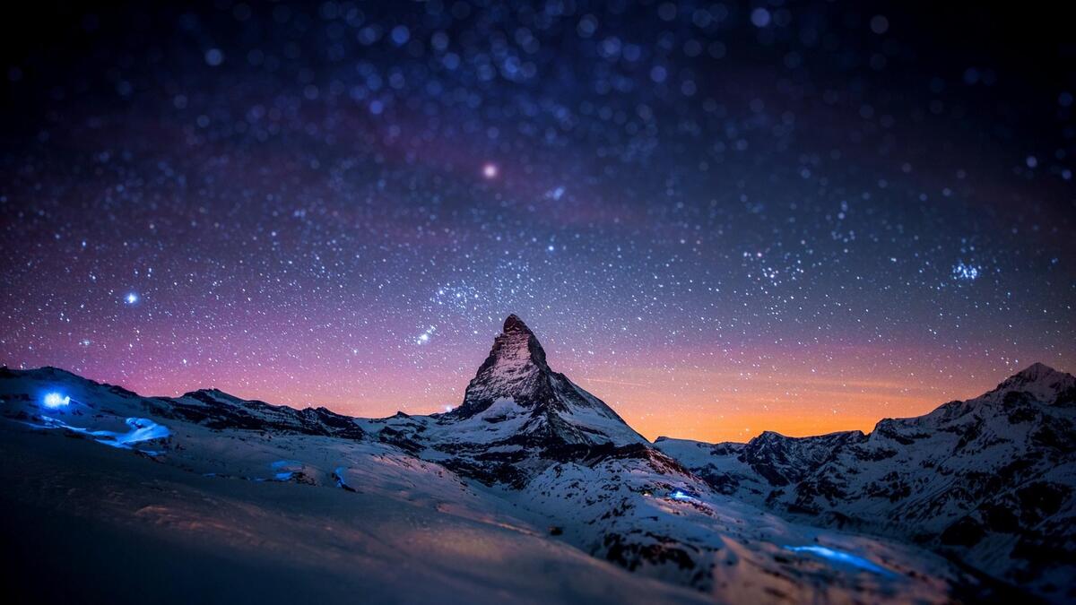 Звездное небо в горах со снежными вершинами