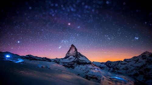 Starry sky in the mountains with snowy peaks