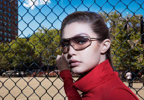 Gigi Hadid in sunglasses by the fence