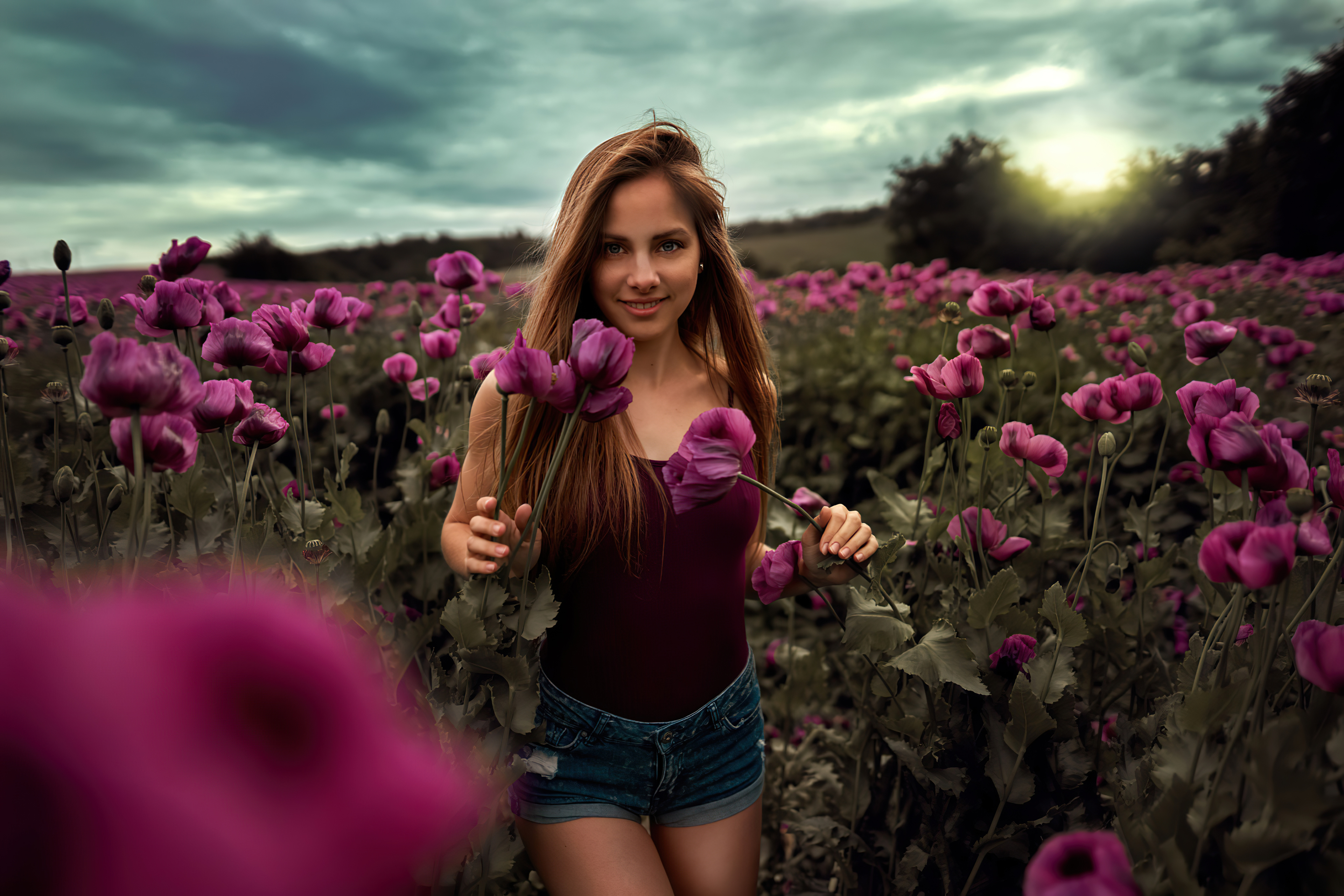 Бесплатное фото Темноволосая девушка гуляет по полю с фиолетовыми цветами