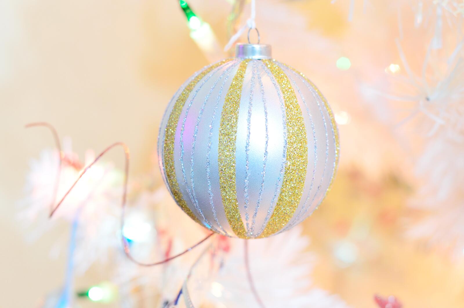 Бесплатное фото Серебристо-золотистый новогодний шарик