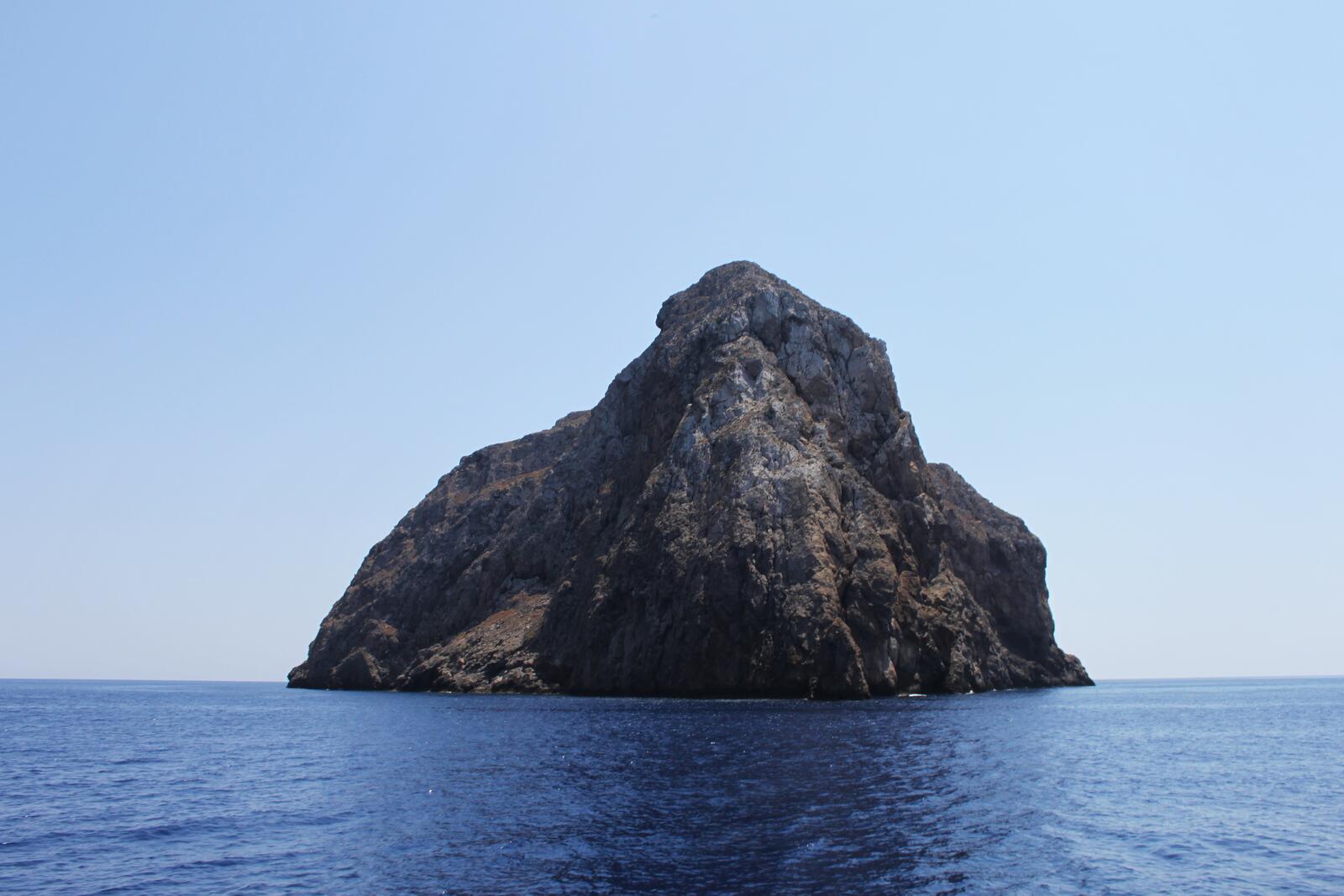 Free photo A huge rock in the middle of the sea near the shore