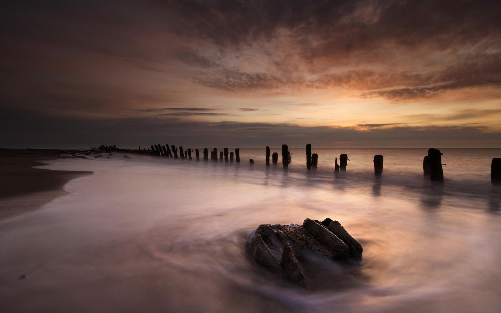 Бесплатное фото Берег моря с разрушенным деревянным мостиком