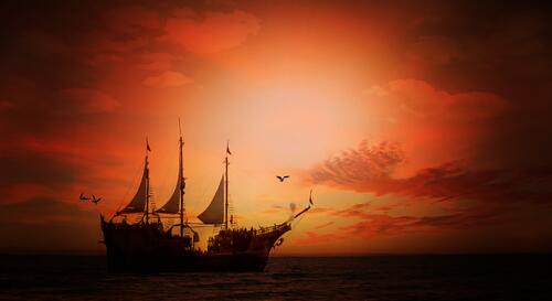 A picture of a large sailing ship at sunset.