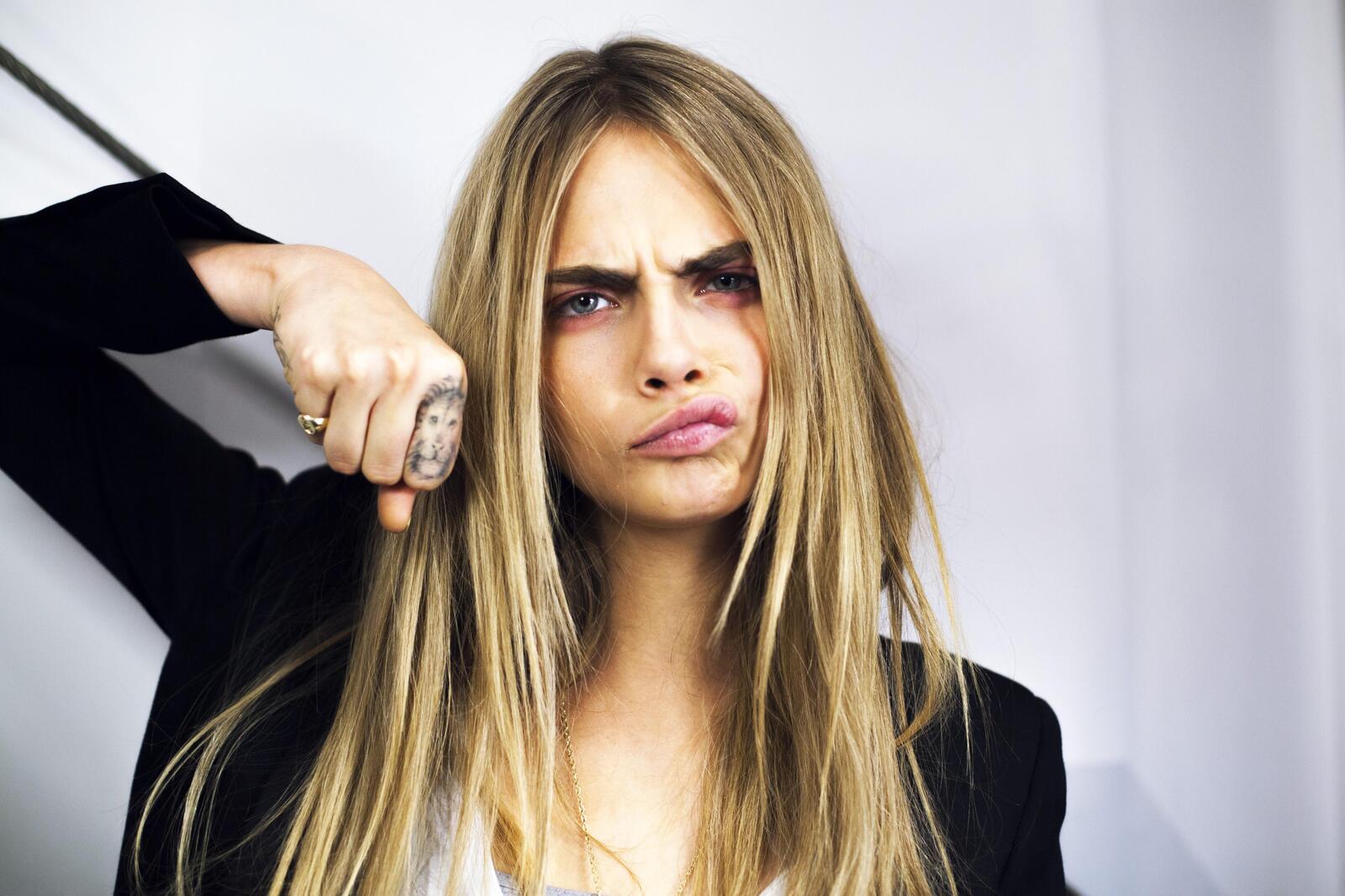 Free photo Cara Delevingne with a lion tattoo on her finger