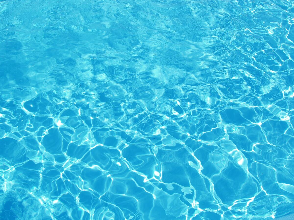 The sun plays on the blue water in the pool