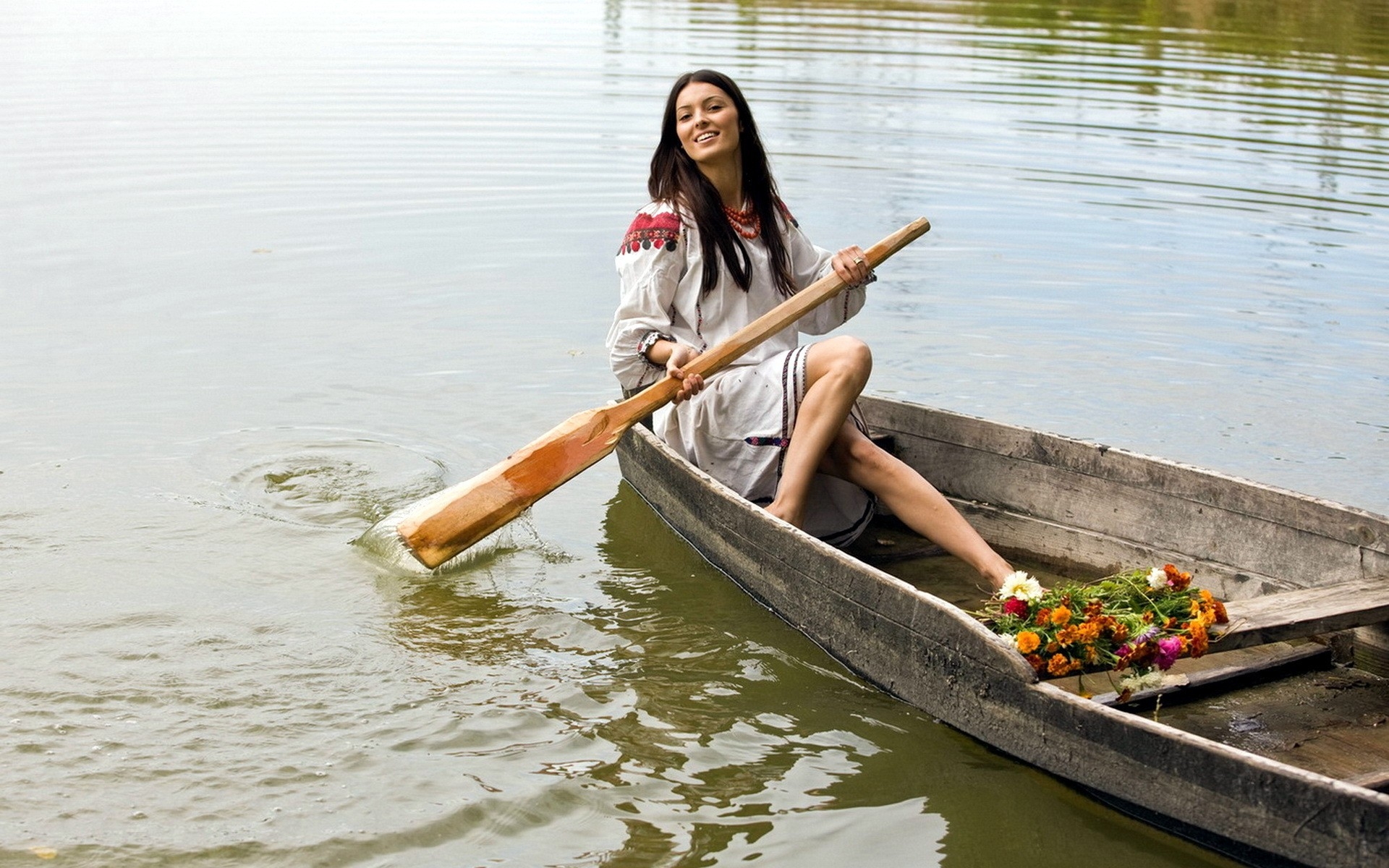 木船上拿着桨的女孩。