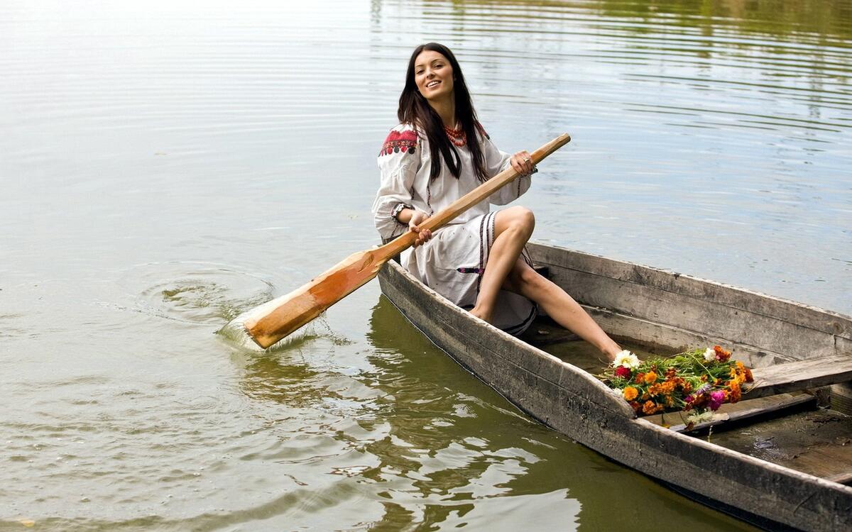 Девушка с веслом в деревянной лодке