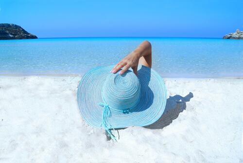 Отдых на пляже в голубой шляпе
