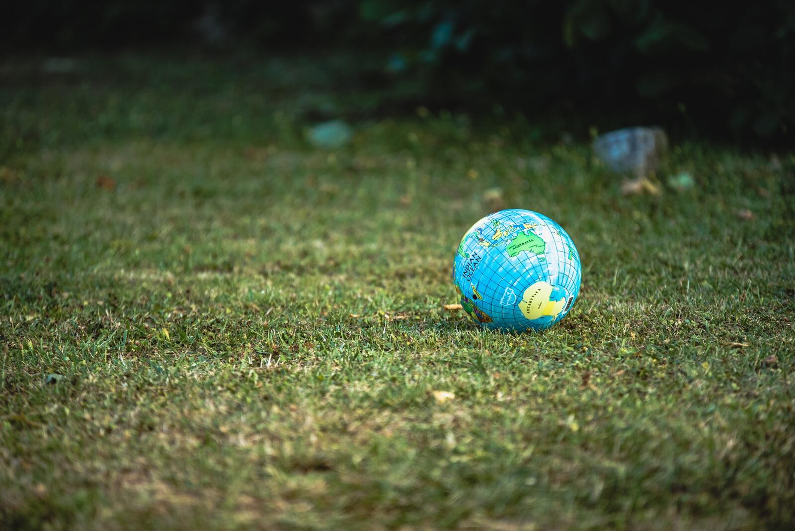 Бесплатное фото Мяч глобус лежит на газоне