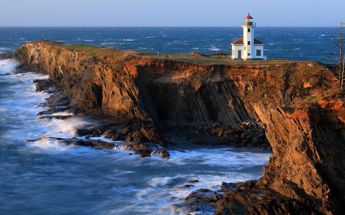 A lighthouse on a rocky ocean shore