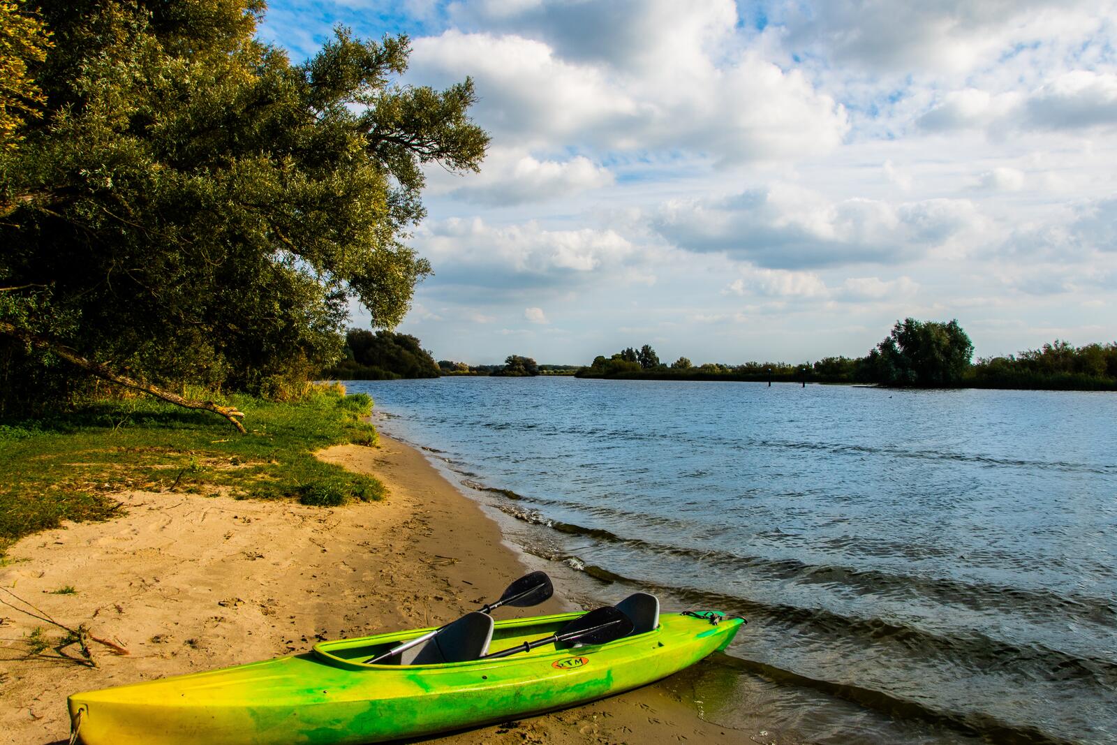 Free photo Green kayak on the riverbank