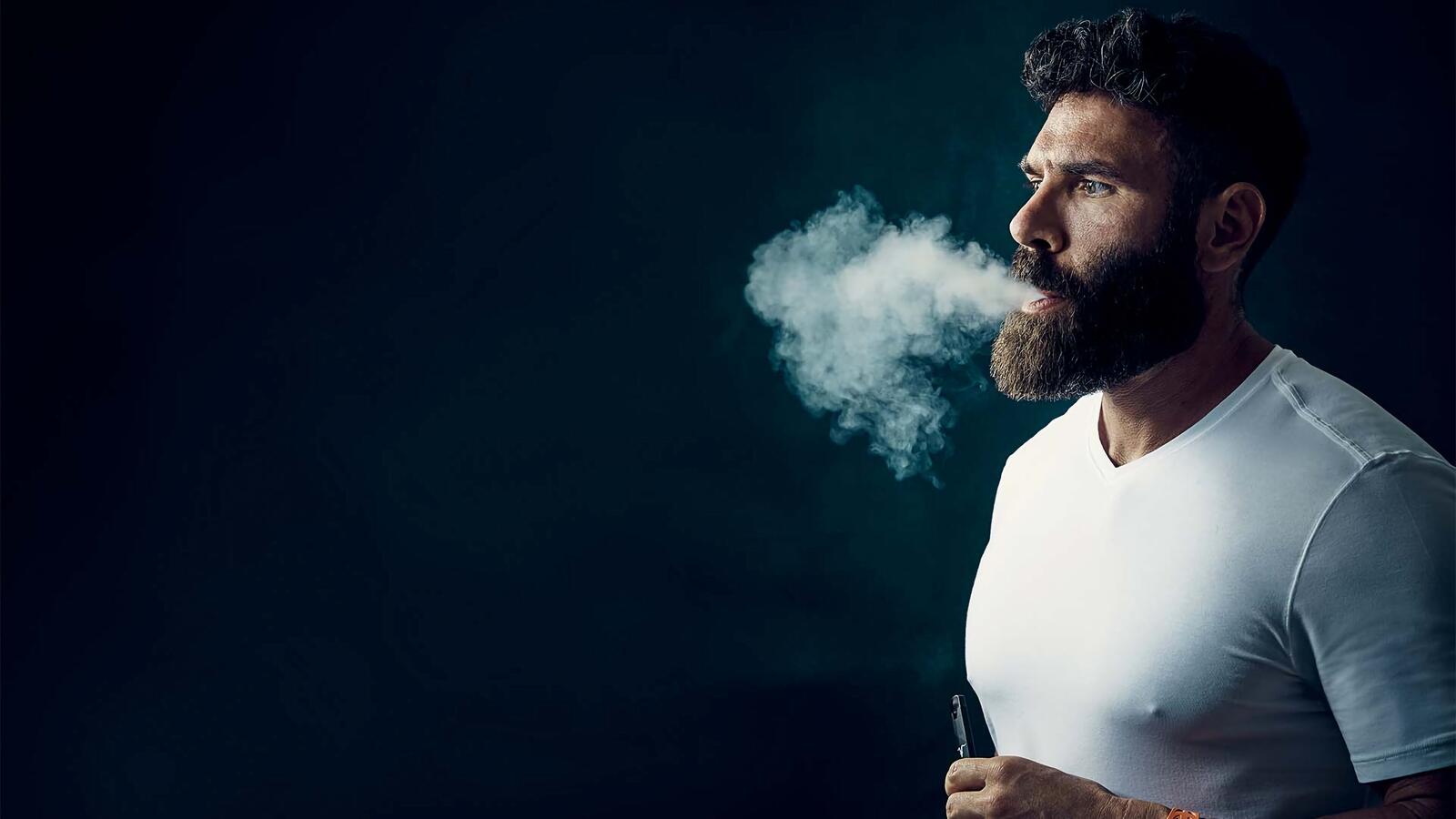 Бесплатное фото Dan Bilzerian выдыхает дым электронной сигареты