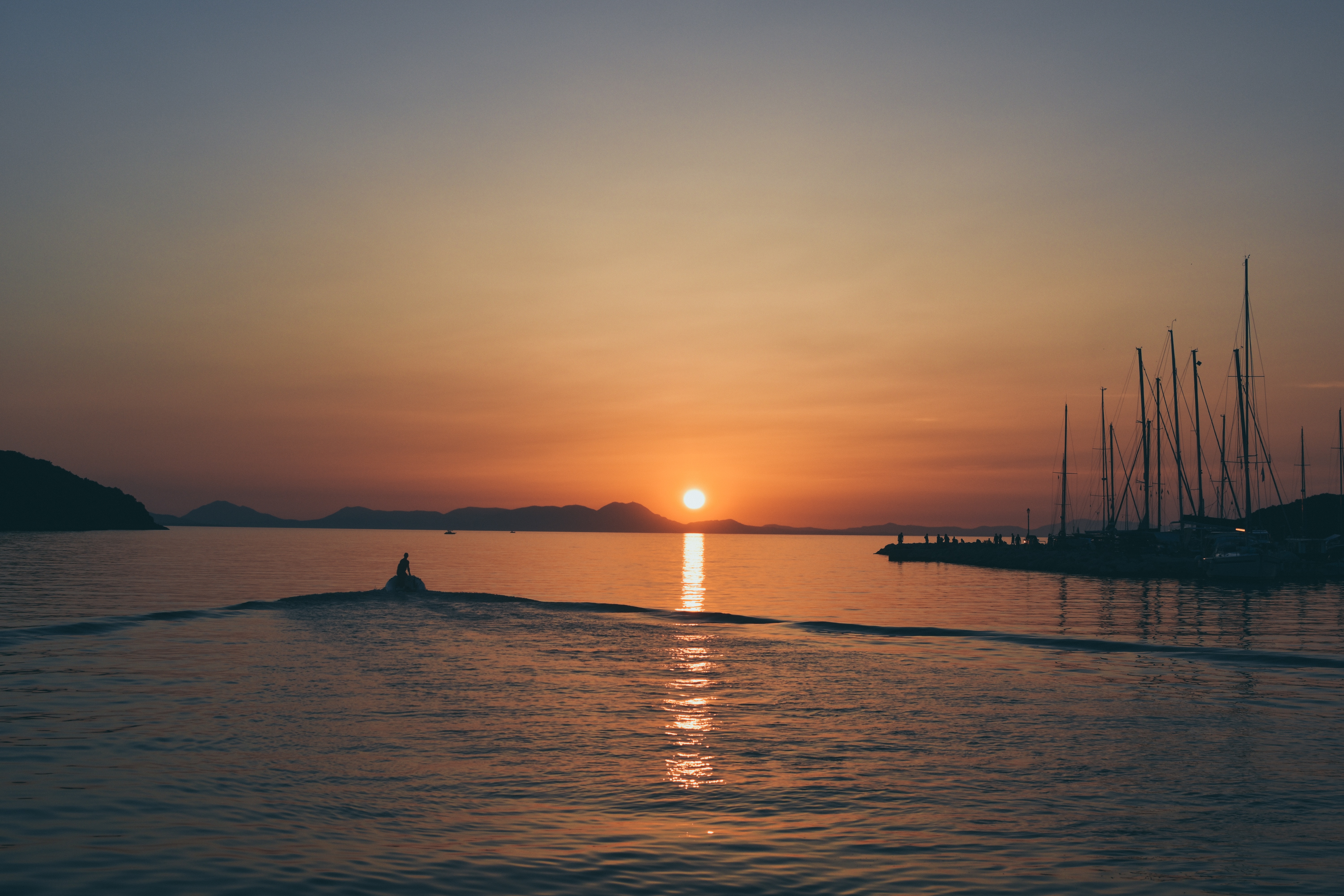 免费照片一艘小船驶入夕阳中