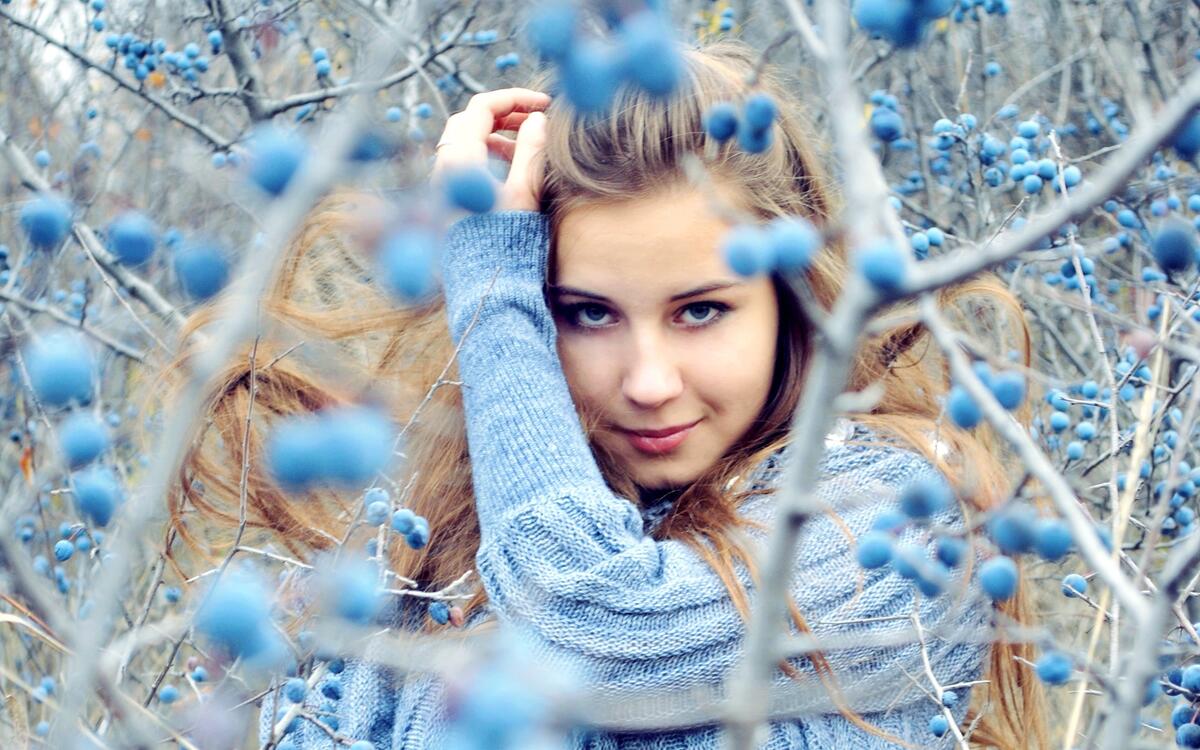 The girl in front of the blueberry bushes.