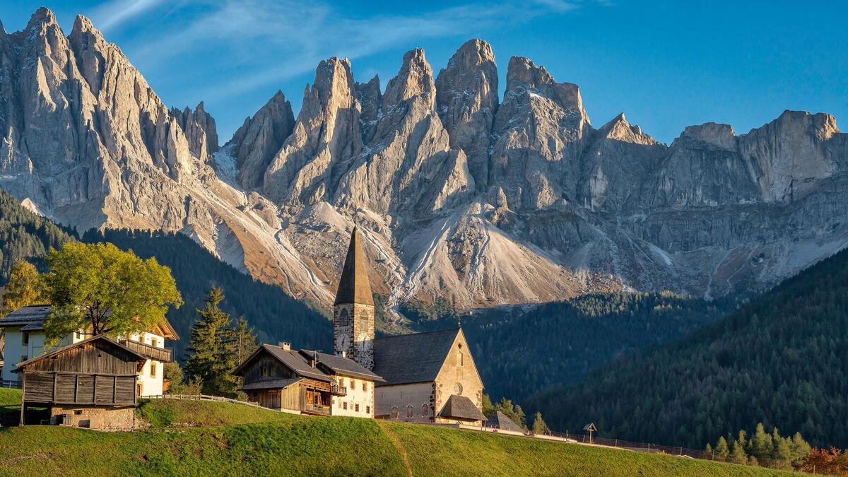 An old church against a backdrop of dolomite alps