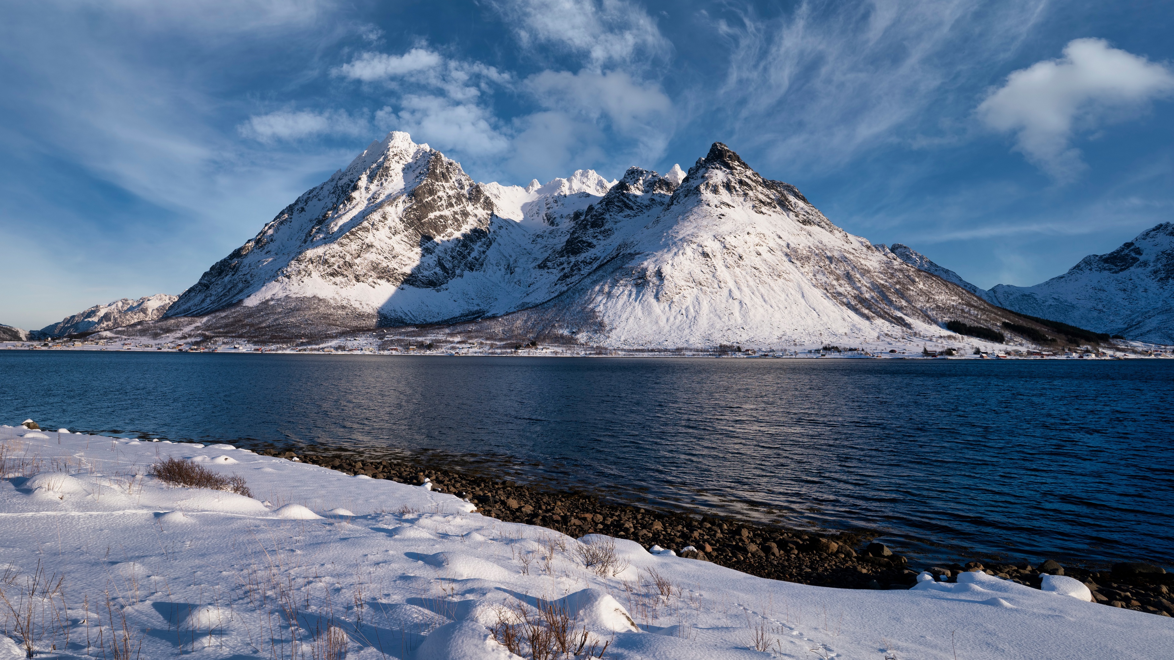Снежные горы у реки в Норвегии