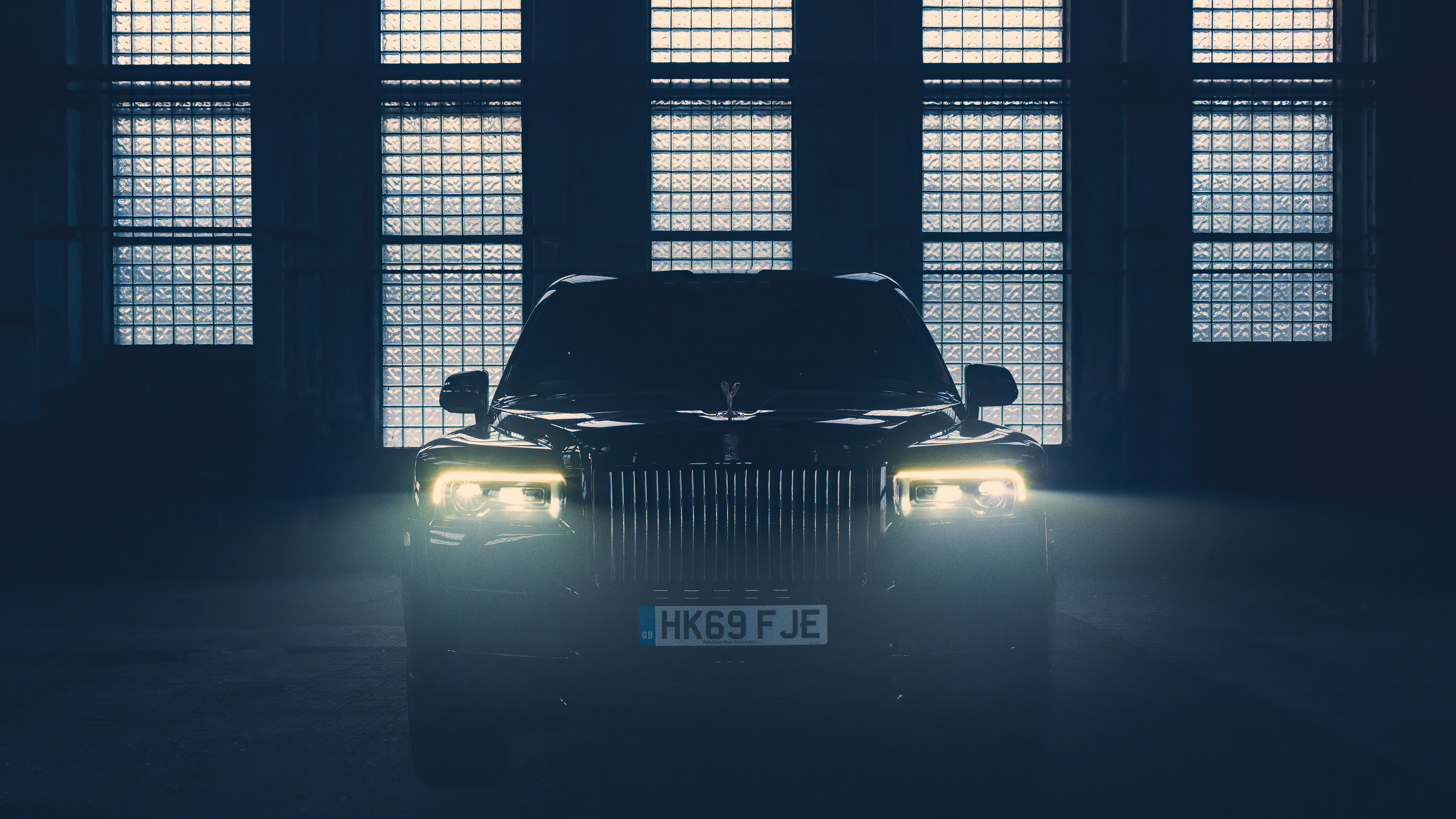 Black Rolls Royce Cullinan with front lights on