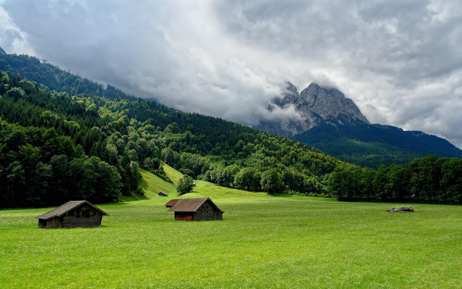 Бесплатное фото Картинка с деревянными домиками на зеленом поле