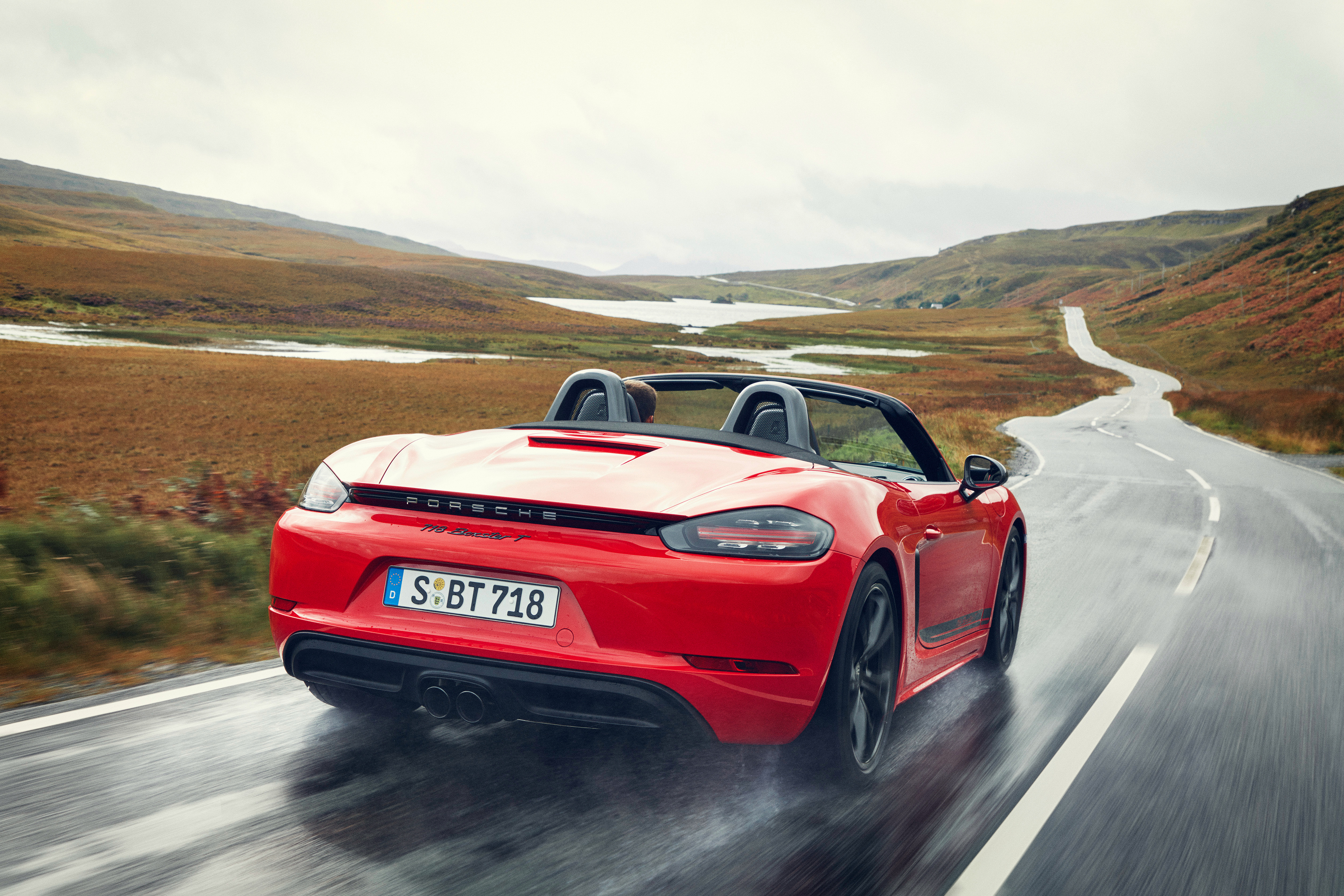 Free photo Red Porsche 718 Cabriolet Driving on Wet Road after Rain