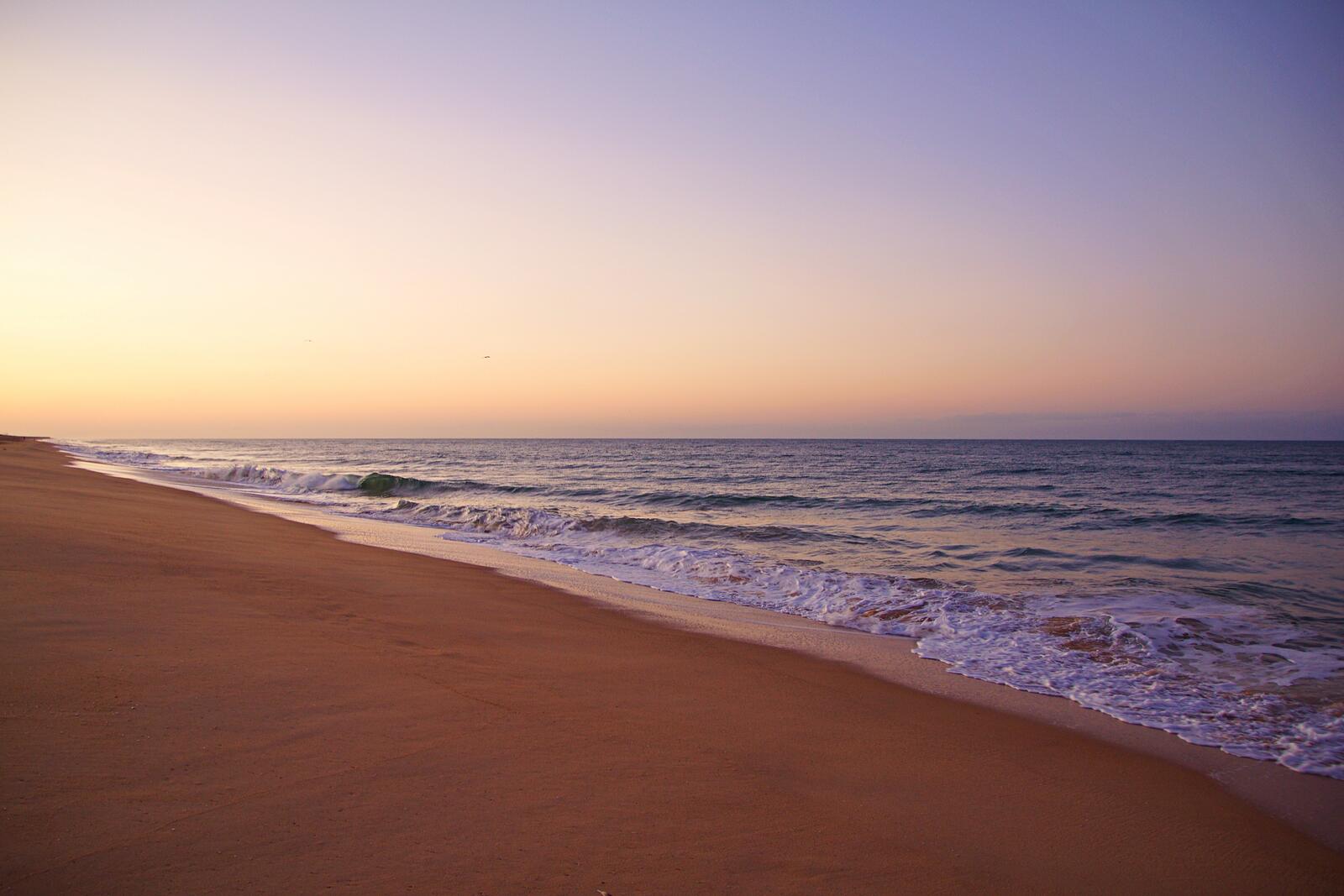 Бесплатное фото Песчаный морской пляж на закате