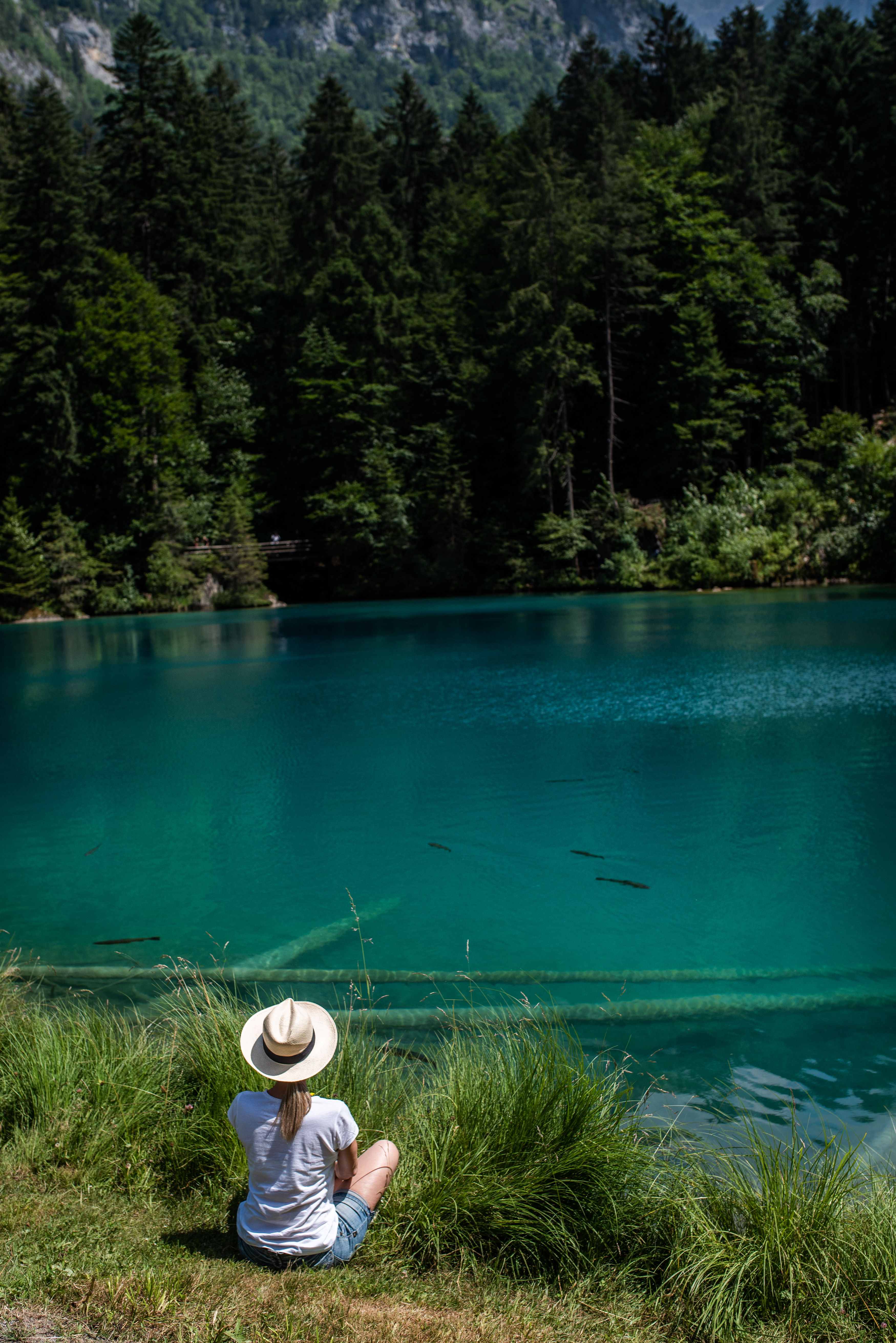 Девушка медитирует у озера с голубой водой