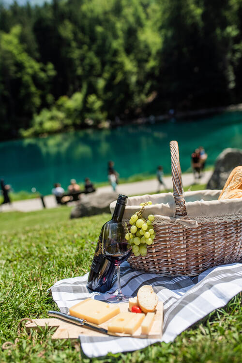 A glass of wine at a summer picnic by the lake