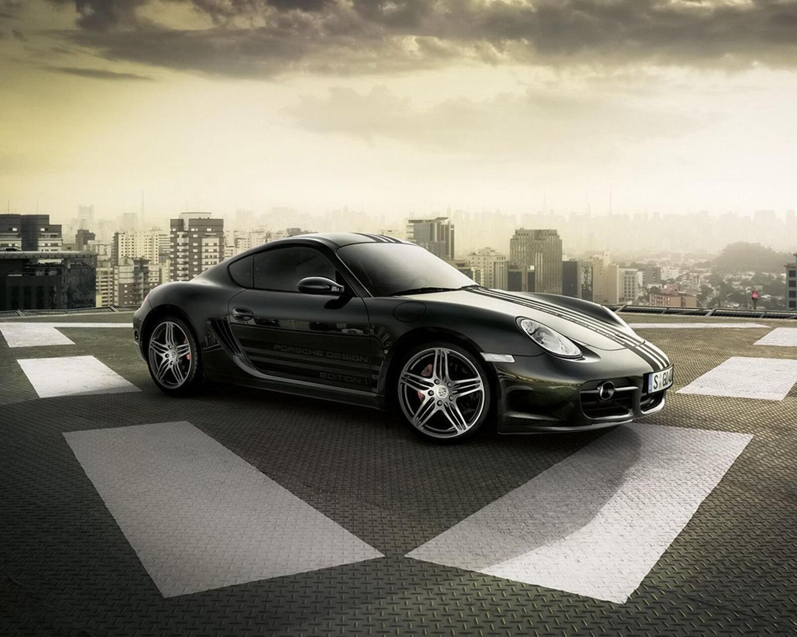Бесплатное фото Porsche Cayman GT на монохромном снимке на фоне города