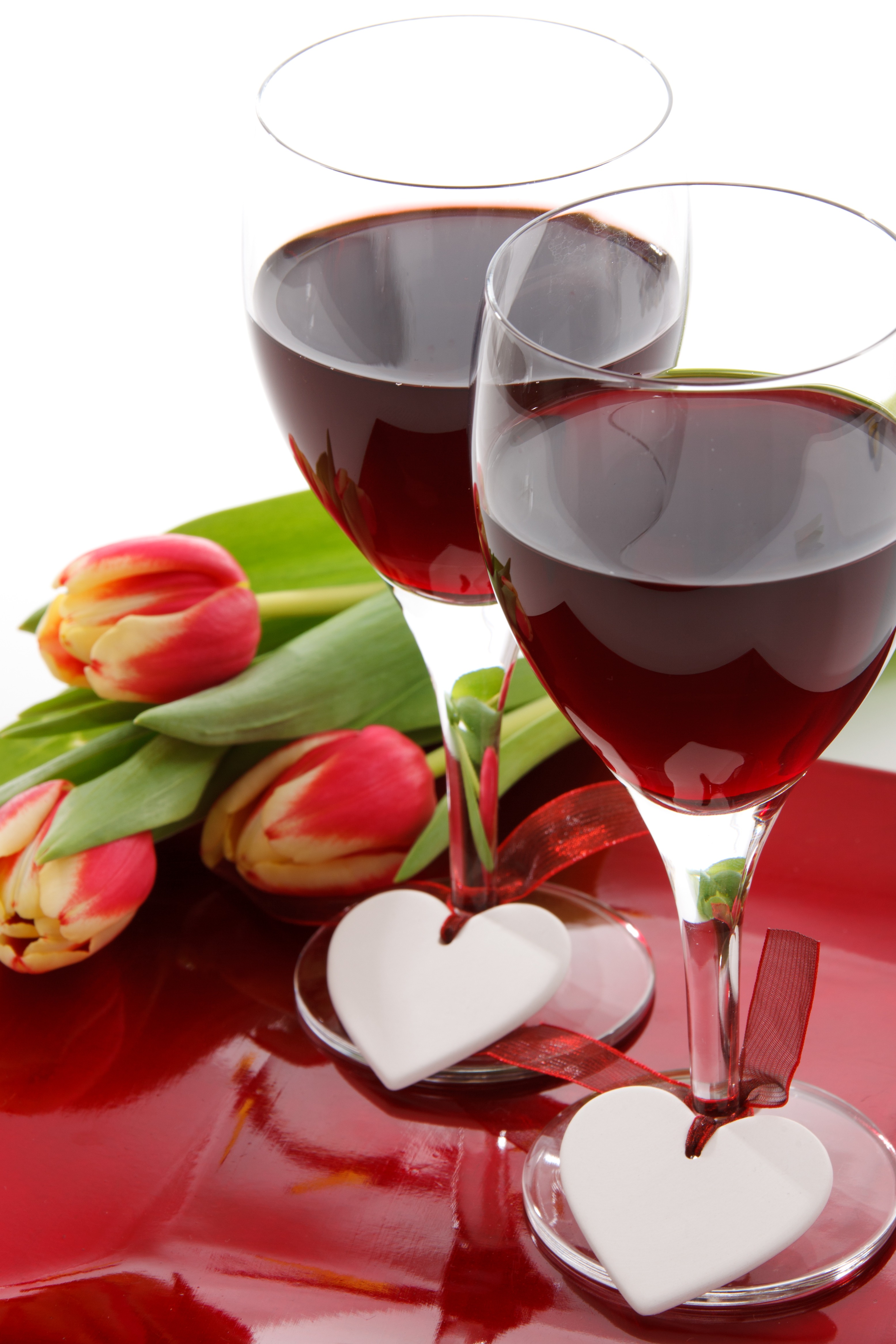 Two glasses of red wine and tulips.