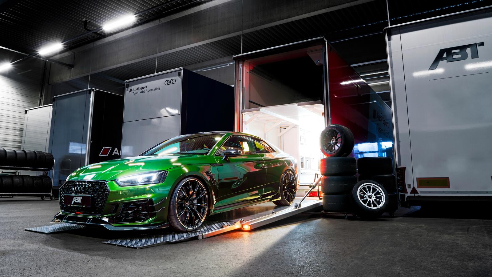 Free photo A green audi rs5-r coupe pulls out of the garage.