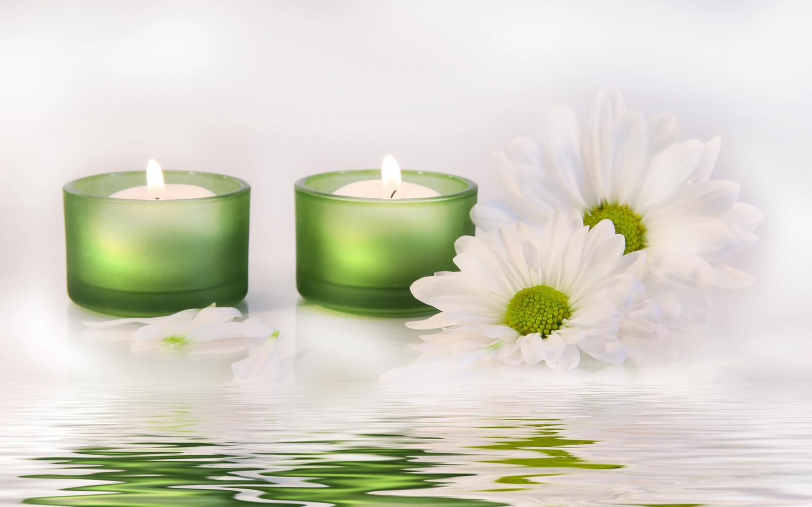 Free photo Two small candles with white daisies.
