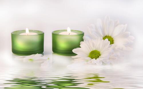 Two small candles with white daisies.