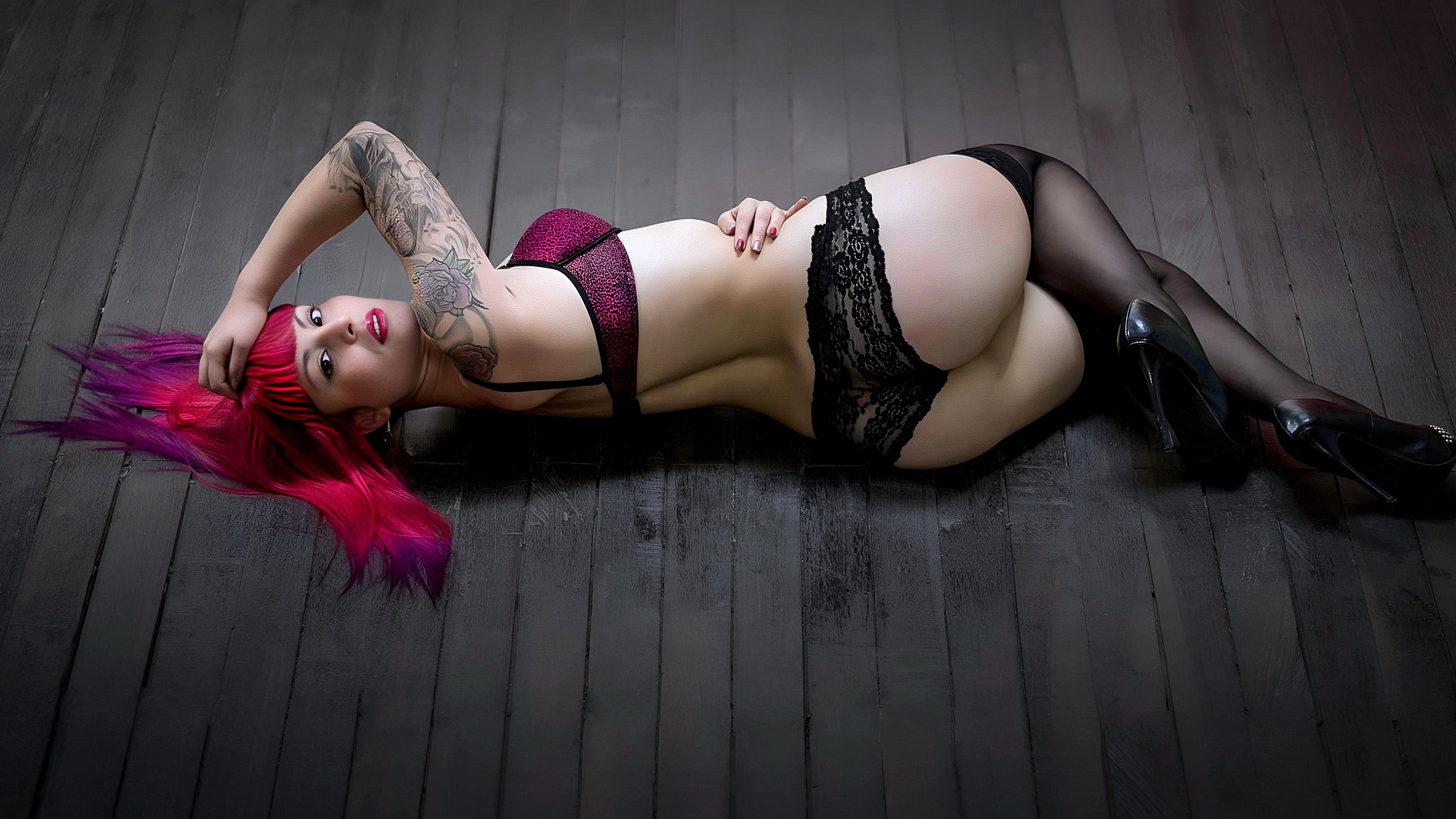A girl with red hair and underwear lies on the floor